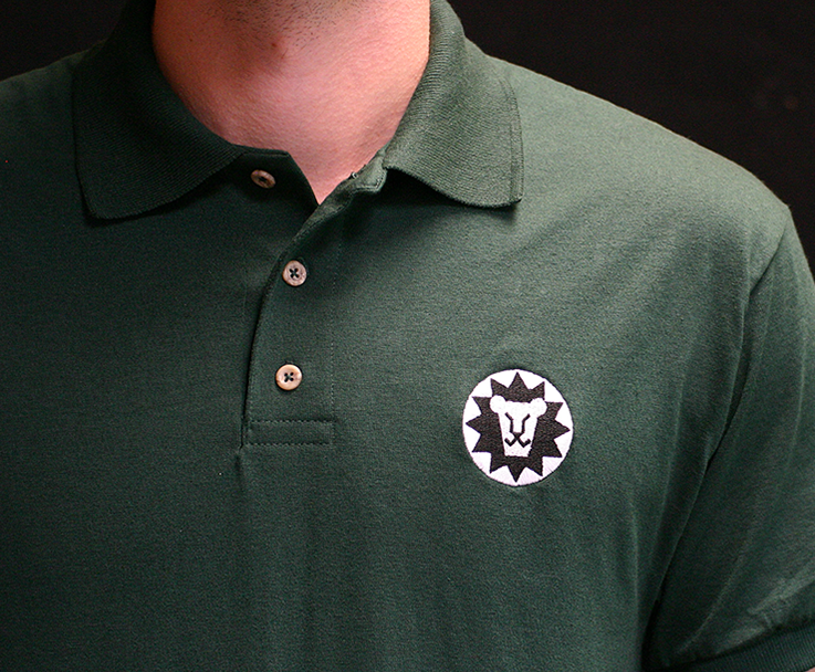 Beardsley model wearing forest green polo shirt featuring beardsley lion logo in white and black